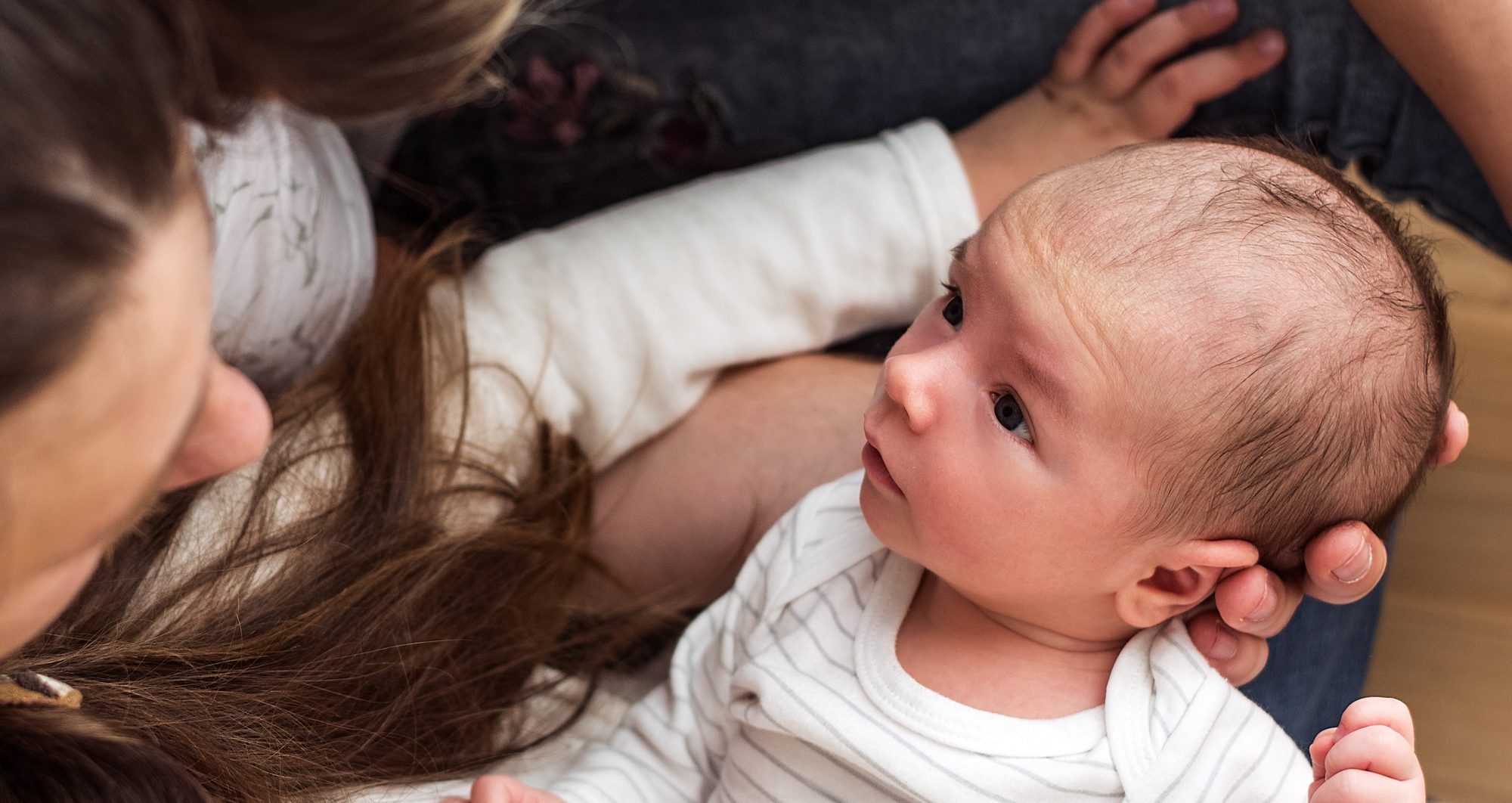 Two parents gazing at their newborn