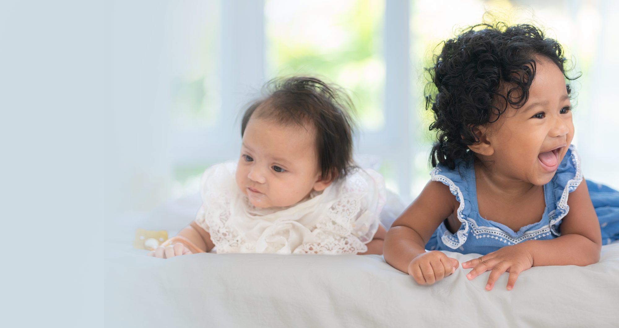 Two happy babies side by side