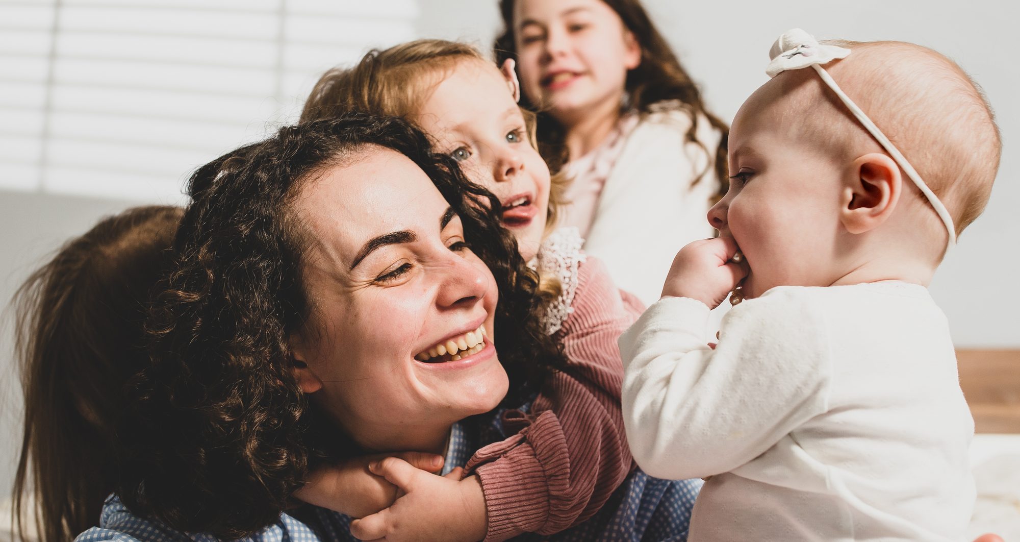 A mother laughing with her daughters