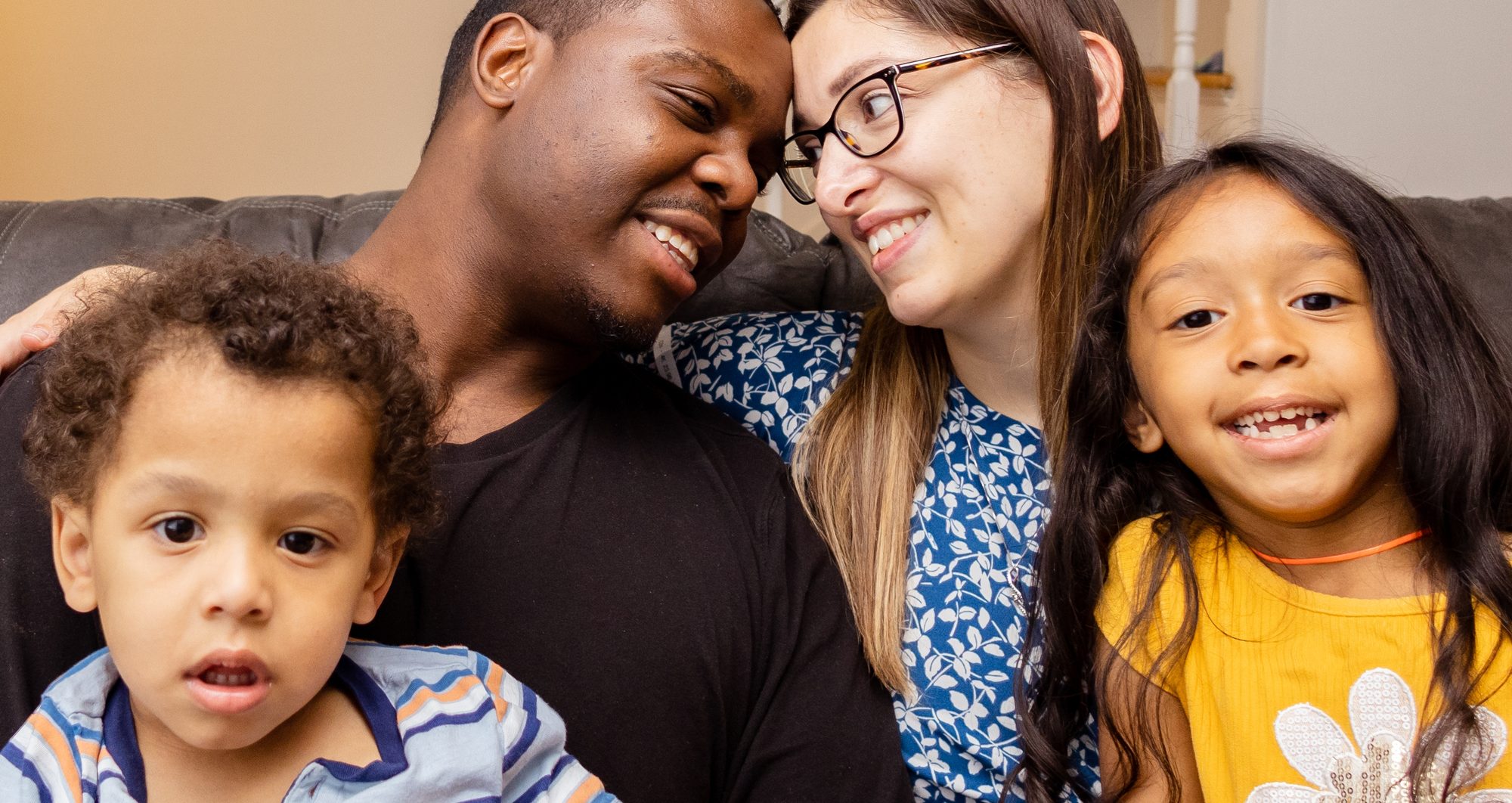 A family of four smiling together