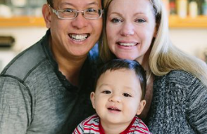 A bi-racial family with their smiling son